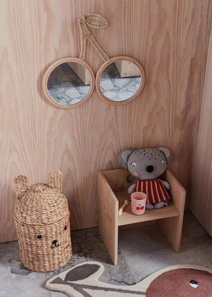 The rattan frame gives the cherry-shaped mirror a natural flair.