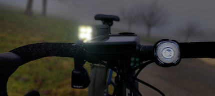 À gauche, la lampe Blinder 900 de Knog, à droite sur le guidon, la Firefly de Lumos comme lampe avant.