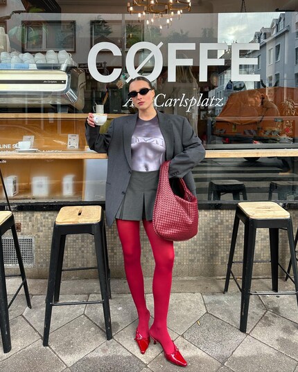 Tutte le cose belle vengono in tre: Lara Bussmann indossa borsa, calze e scarpe rosse.