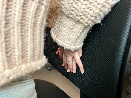 Fold your hands on top of each other and press them against the back of the chair so that your lower back tightens.