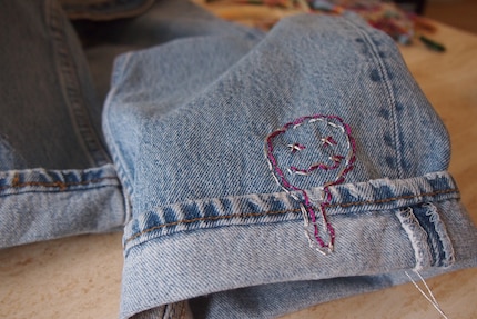 ... je fais dégouliner un émoji sur l’ourlet de la deuxième jambe.