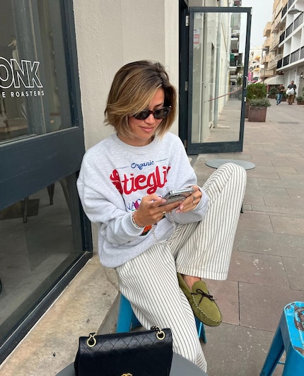 Sweatshirt and trousers with that classic striped pyjama look – a simple, trendy combination.