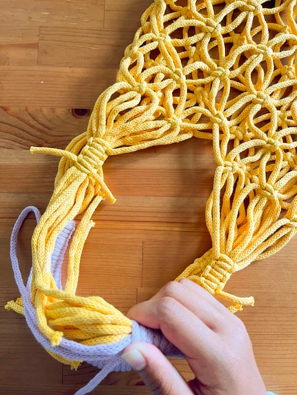 Das lila Seil wickle ich mit starkem Zug um die gelben Seile. Leider muss ich es mehrmals wiederholen.