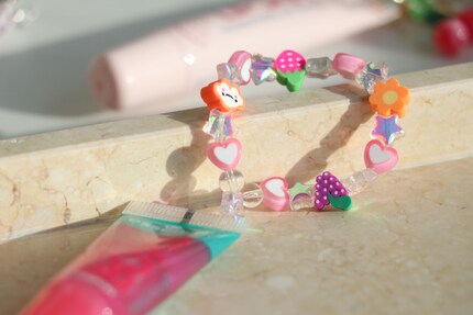 Ho impreziosito il gloss Essence con un elastico carico di perle. In questo modo può essere indossato anche al polso.