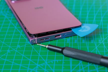 Draai een schroef en haal dan de achterkant eraf.