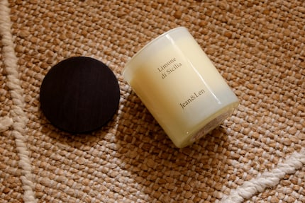 La candela è contenuta in un semplice barattolo di vetro con un coperchio di legno che può essere utilizzato anche come sottobicchiere.