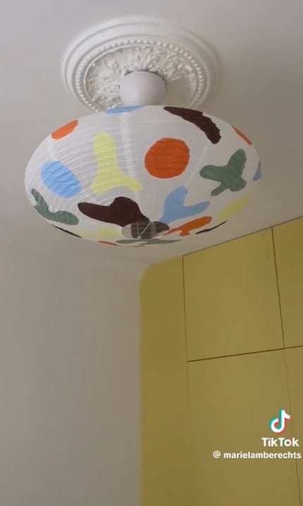 …painting vibrant, organic shapes on her lampshade.