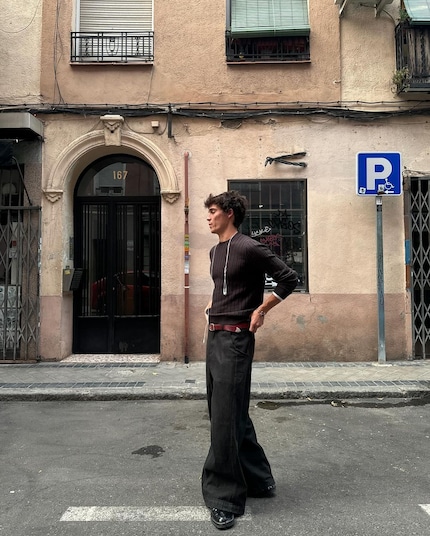 Haut marron foncé avec pantalon noir, ceinture rouge avec chaussures noires : cette tenue enfreint toutes les « règles ».