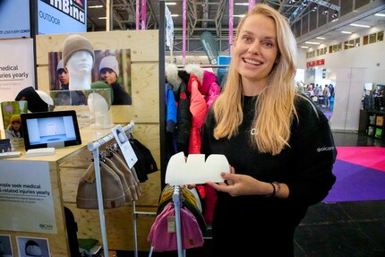 Sofie Hellström shows the protective material that is incorporated into the cap at the international sports trade fair ISPO.