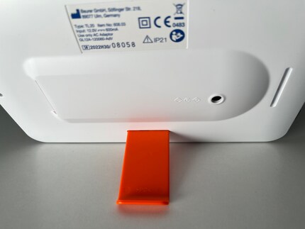 De oranje standaard kan gemakkelijk verplaatst worden. Aan de lange kant is de lamp liggend bevestigd...