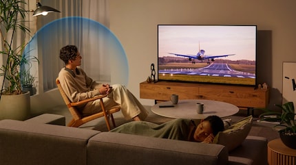 Das muss eine sensationelle Landung sein, die er da in Gedanken sinnierend beobachtet, während eine Frau im Vordergrund seelenruhig schläft.