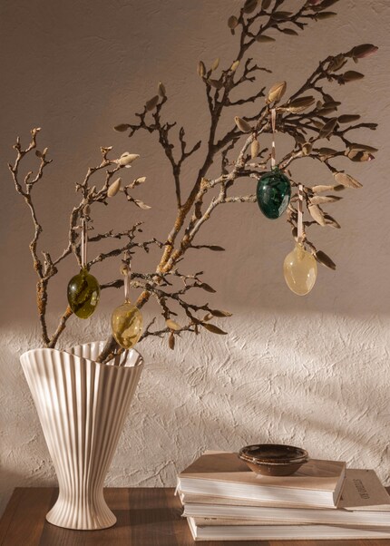 Ein Hingucker: Der Osterstrauch in einer Plissee-Vase vereint Eleganz und frühlingshafte Leichtigkeit.