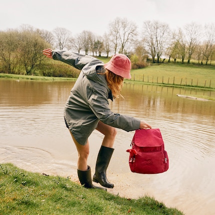 The City Pack by Kipling in red with the characteristic monkey pendant.