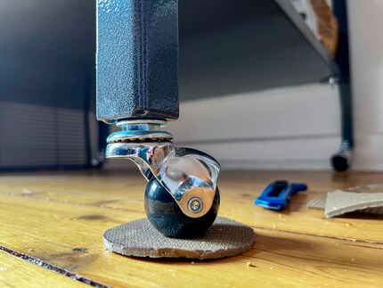 Mit dem Untersetzer steht der Käfig wesentlich stabiler. Und auch die Holzdielen freuen sich.