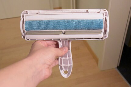 La surface électrostatique bleue absorbe les poils qui finissent dans le bac à l’arrière du rouleau.