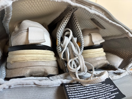 Ein Sneaker links, ein Sneaker rechts, in der Mittelwand können die Schuhbänder unterkommen.