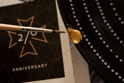 Ist der Kleber fast trocken, sorgt zusätzlich aufgepinselter Goldstaub fürs optische Finish.
