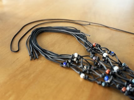 Die losen Enden in zwei Partien teilen und oben bogenförmig zusammenbringen. Aus der Restkordel eine Schlaufe legen.