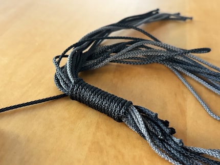 Vom offenen Schlaufenende aus werden alle Schnüre umwickelt.