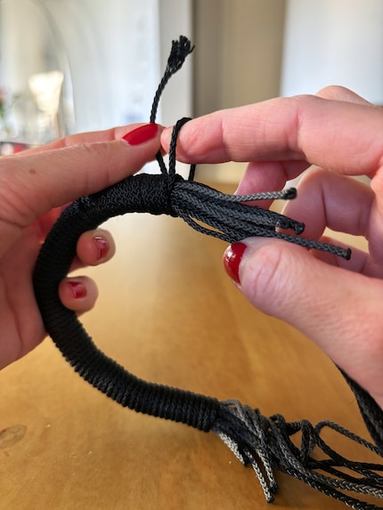 Im letzten Schritt wird der Wickelfaden durch die Schlaufe gesteckt und nach innen gezogen.