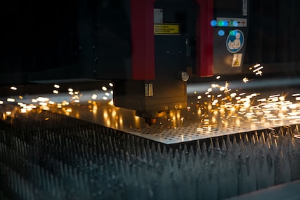 Die Maschine lasert Löcher in die Edelstahlplatte – später kommen hier die Gumminoppen durch.