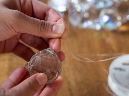 Ich ziehe den Nylonfaden durch die Quetschperle, den Kristall und wieder durch die Perle …