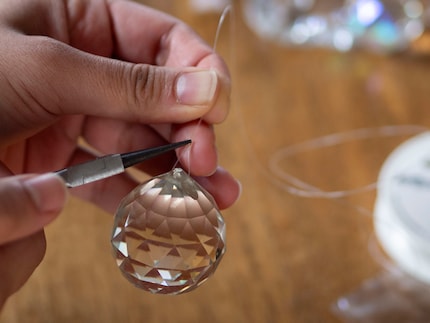 ... und drücke die Perle zusammen. So bleibt der Faden fixiert.