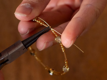 Darum halte ich den Ring gut fest, während ich die Quetschperle flachdrücke.