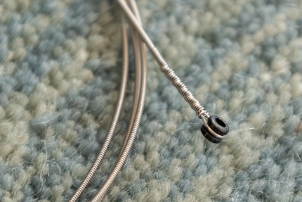 Stahlsaiten haben am Ende eine Verdickung, um sie zu fixieren.