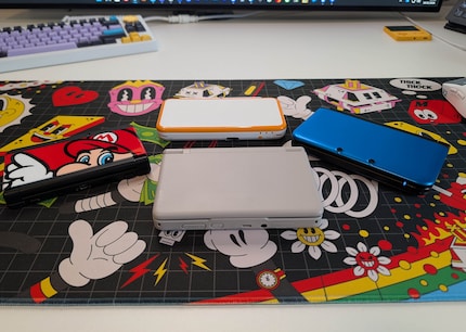 Der Ayn Thor (grau) neben drei verschiedenen Nintendo-DS-Modellen.