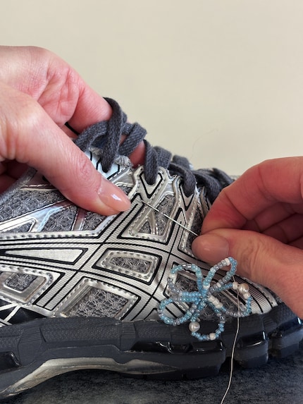 Den Draht mit Hilfe einer Nadel durch den Schuh stechen.