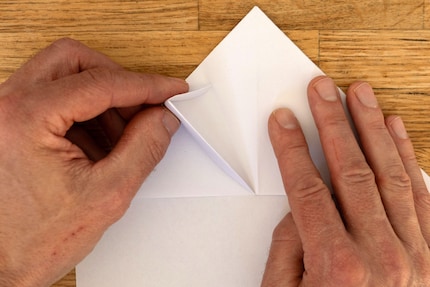 Klappe die überstehende Papierspitze nach hinten um ...