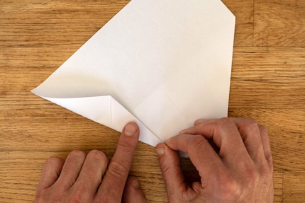 Nun drehst du das Blatt um und machst dich an die Seiten. Einmal nach oben falten ...