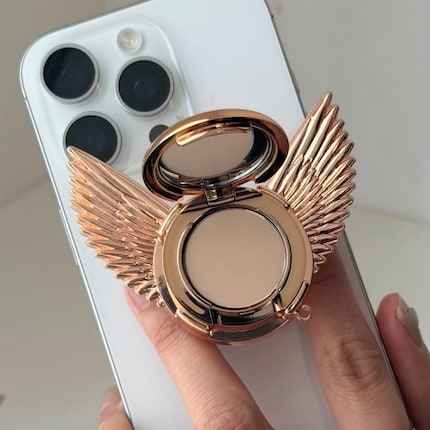 Das Airbrush Flawless Finishing Powder als ausziehbarer Smartphone-Griff.