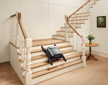 The Cyber X travels up the stairs on caterpillar tracks with the robot hoover docked.
