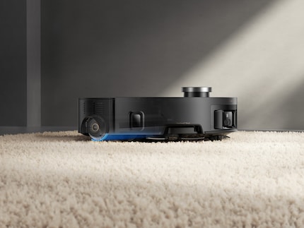 Auf Teppichen hebt der Roboter die nasse Mopprolle an und deckt sie ab.