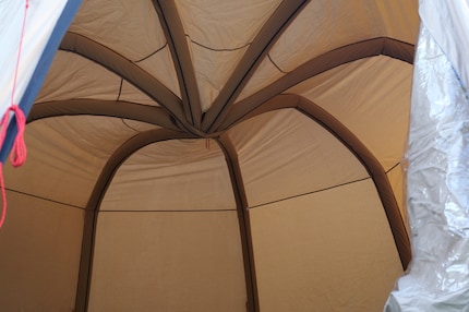Een laatste zetje, dan is de koepel omhoog en de tent stabiel.