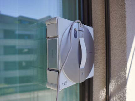 Der Roboter sprüht mit Düsen Reinigungsflüssigkeit auf die Scheibe und putzt sie dann.