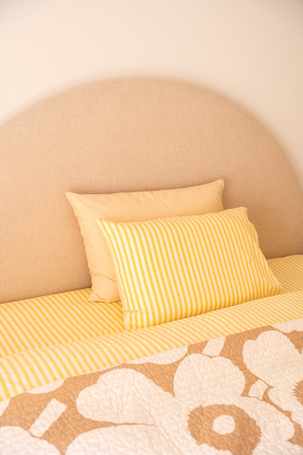 Sonnig, aber nicht grell: Das Gelb-Weiss fügt sich ins Schlafzimmer ein, ohne es zu dominieren.