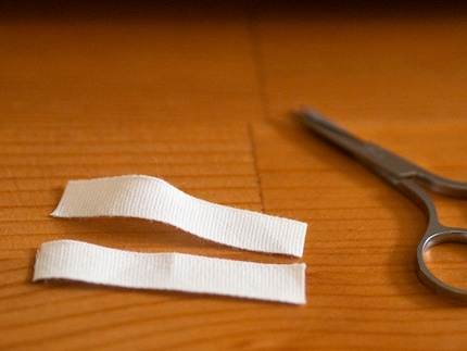 Das weisse Stoffband soll unter dem Bettlaken verschwinden.