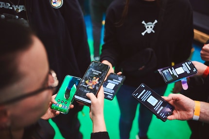 Ein Blick auf die Smartphones zeigt, wie die Freundesfunktion der Polaris-App in der Praxis aussieht. Gleich mehrere Besucher tauschen ihre Codes aus.